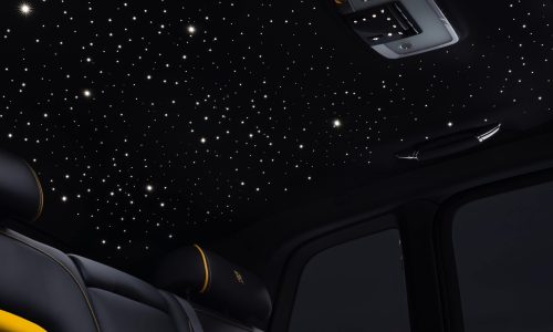 Shows the starlight headliner accessory fitted in a Rolls-Royce Cullinan, the dark shot highlighting the constellation of lights against the material of the headliner